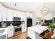 Open kitchen with white cabinets, stainless steel appliances, and an island overlooking the living area at 4800 S Tabor St, Morrison, CO 80465