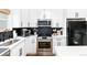 Well-lit kitchen with stainless steel appliances, black backsplash, and white cabinets at 4800 S Tabor St, Morrison, CO 80465
