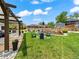 Landscaped backyard featuring a lush lawn, fire pit area, and a pergola-covered patio for outdoor entertaining at 6111 W Fremont Dr, Littleton, CO 80128