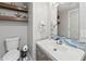 Stylish half-bathroom features floating shelves, a modern vanity with a blue-tiled backsplash, and a sleek toilet at 6111 W Fremont Dr, Littleton, CO 80128