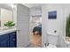 Bathroom with blue vanity and view into adjacent bedroom; plant and natural light at 6111 W Fremont Dr, Littleton, CO 80128