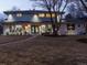 Inviting two-story home with well-maintained landscaping, a mature tree, and soft lighting, showcasing its curb appeal at dusk at 6111 W Fremont Dr, Littleton, CO 80128