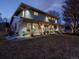Beautiful two-story home featuring a covered patio and lush landscaping, illuminated by warm outdoor lighting at twilight at 6111 W Fremont Dr, Littleton, CO 80128