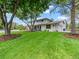Well-maintained front yard with expansive green lawn, mature trees, and a charming two-story home at 6111 W Fremont Dr, Littleton, CO 80128