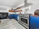 Updated kitchen featuring a stainless steel range, custom cabinets, butcher block counters, and an exposed brick fireplace at 6111 W Fremont Dr, Littleton, CO 80128