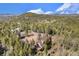 Aerial view of a cozy cabin nestled in a tranquil forest setting with mountain views, emphasizing privacy and natural beauty at 9185 Jill Dr, Conifer, CO 80433