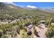 An aerial view of a charming home in a wooded area with mountain views showcasing the neighborhood and tranquil landscape at 9185 Jill Dr, Conifer, CO 80433