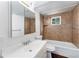 Bright bathroom features a tub with tile surround and a vanity with a framed mirror at 9185 Jill Dr, Conifer, CO 80433