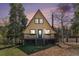 Charming A-frame cabin featuring a cozy front porch and nestled among mature trees at dusk at 9185 Jill Dr, Conifer, CO 80433