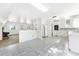 Open-concept kitchen featuring white cabinets and countertops, with a view into the adjacent living space at 9185 Jill Dr, Conifer, CO 80433