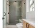 Shower with patterned tile and a glass door, next to a vanity with quartz countertop at 1846 Chestnut Ave, Erie, CO 80516