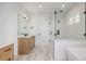 Modern bathroom with a walk-in shower, double vanity, and neutral tile flooring at 1846 Chestnut Ave, Erie, CO 80516