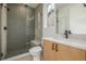Shower with patterned tile and a glass door, next to a vanity with quartz countertop at 1846 Chestnut Ave, Erie, CO 80516