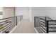 Bright hallway with modern black iron railings, white walls, and neutral carpet at 1846 Chestnut Ave, Erie, CO 80516