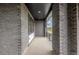 Charming front porch with brick columns, black ceiling, and wrought iron railing, creating an elegant entrance at 1846 Chestnut Ave, Erie, CO 80516