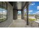 Inviting front porch featuring brick columns, a black ceiling, and a wrought iron railing at 1846 Chestnut Ave, Erie, CO 80516
