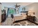 Bedroom with hardwood floors, ceiling fan, and large window with blue curtains at 3265 W 11Th Avenue Ct, Broomfield, CO 80020