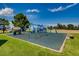 Colorful playground set on a safety surface, surrounded by green grass and trees at 3265 W 11Th Avenue Ct, Broomfield, CO 80020
