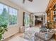 Inviting sunroom with wicker furniture, area rug, and view into dining room at 3265 W 11Th Avenue Ct, Broomfield, CO 80020