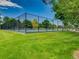 Fenced tennis court surrounded by mature trees and greenery in a well-kept outdoor space at 3265 W 11Th Avenue Ct, Broomfield, CO 80020