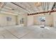 Unfinished basement with exposed beams, a treadmill, and access to a patio at 9002 Birch Run Dr, Parker, CO 80134
