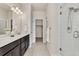 Sleek bathroom features a double vanity, walk-in closet, and modern glass-enclosed shower at 9002 Birch Run Dr, Parker, CO 80134