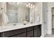 Bathroom featuring double vanity sinks, large mirror, and a tiled shower at 9002 Birch Run Dr, Parker, CO 80134