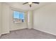 Bedroom with large window offering neighborhood views and a modern ceiling fan at 9002 Birch Run Dr, Parker, CO 80134