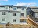 Back exterior view of the townhome with a small deck and walk out basement to small patio area at 9002 Birch Run Dr, Parker, CO 80134