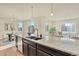 Open kitchen featuring a granite-topped island, modern lighting, and view to an adjacent dining and living area at 9002 Birch Run Dr, Parker, CO 80134