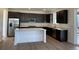 Modern kitchen featuring dark cabinetry, stainless steel appliances, and an island at 544 Twilight St, Erie, CO 80516