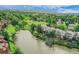 Aerial view of a serene lake surrounded by lush greenery and homes, offering a tranquil living environment at 12658 W 1St Pl # 78, Denver, CO 80228