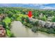 Aerial view showcasing a townhome with a deck overlooking a serene lake and mature trees at 12658 W 1St Pl # 78, Denver, CO 80228