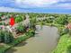 Aerial view of townhomes with a lake and a wooden pier, surrounded by mature trees and landscaping at 12658 W 1St Pl # 78, Denver, CO 80228
