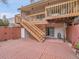 A spacious backyard featuring a brick patio, deck with stairs, and a sliding glass door that seamlessly blends indoor/outdoor living at 12658 W 1St Pl # 78, Denver, CO 80228