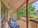 Tranquil outdoor deck with striped chairs offering a serene view of mature trees at 12658 W 1St Pl # 78, Denver, CO 80228