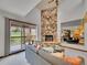 Light-filled living room with deck access and an impressive stone fireplace feature at 12658 W 1St Pl # 78, Denver, CO 80228