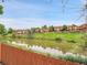 Scenic view of a pond with several houses, captured from behind a wooden fence at 12658 W 1St Pl # 78, Denver, CO 80228