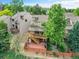 Aerial view of a townhouse with a wooden deck and brick patio surrounded by a fenced yard and mature trees at 12658 W 1St Pl # 78, Denver, CO 80228