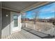 Tranquil back deck with a covered area, a white railing, and a serene outdoor view, offering a perfect relaxation space at 2472 W Peakview Ct, Littleton, CO 80120