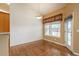 Bright dining area with hardwood floors, a chandelier, a window with scenic views, and a door leading to the outside at 2472 W Peakview Ct, Littleton, CO 80120