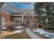 Inviting home entrance featuring a brick facade, a cozy porch, a well-maintained walkway and attractive landscaping at 2472 W Peakview Ct, Littleton, CO 80120