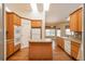 Bright kitchen featuring wood cabinets, an island, hardwood floors, and natural light from skylights at 2472 W Peakview Ct, Littleton, CO 80120