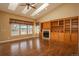 Bright living room featuring hardwood floors, a cozy fireplace, a built-in entertainment center and ample natural light at 2472 W Peakview Ct, Littleton, CO 80120