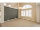 Sunlit living room showcasing a large window, vaulted ceilings, and comfortable carpeting at 2472 W Peakview Ct, Littleton, CO 80120