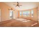 Bright living room featuring a ceiling fan, large windows, and views, creating an inviting atmosphere at 2472 W Peakview Ct, Littleton, CO 80120