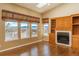 Inviting living room with hardwood floors, a cozy fireplace, built-in shelving and plenty of natural light from the windows at 2472 W Peakview Ct, Littleton, CO 80120