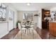 Modern dining room with a glass table, four white chairs, and access to natural light, next to the kitchen at 500 E 11Th Ave # 401, Denver, CO 80203