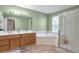 Well-lit bathroom featuring a corner tub, walk-in shower, and a dual sink vanity at 801 S 15Th Ave, Brighton, CO 80601
