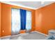 Inviting bedroom features bright orange walls and patterned curtains at 801 S 15Th Ave, Brighton, CO 80601